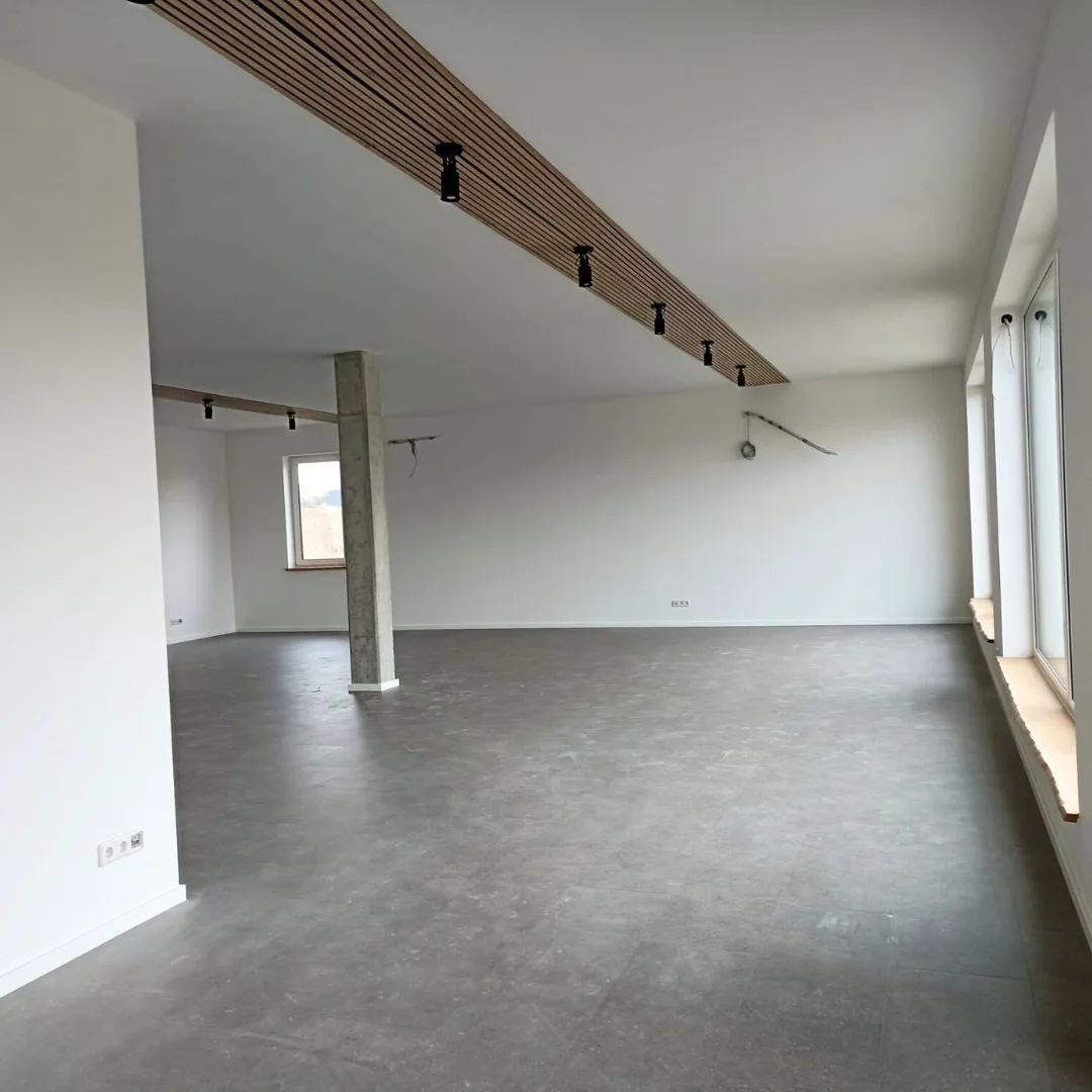 Fertig ausgebauter Büroraum mit abgehängter Lamellendecke und Schienenstrahlern