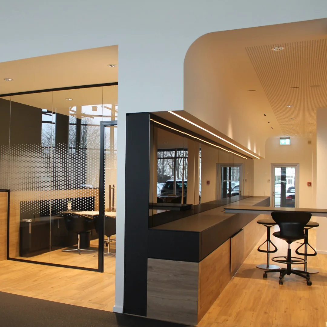 Büroeinrichtung mit Empfangstheke, Glaswand und abgehängter Decke