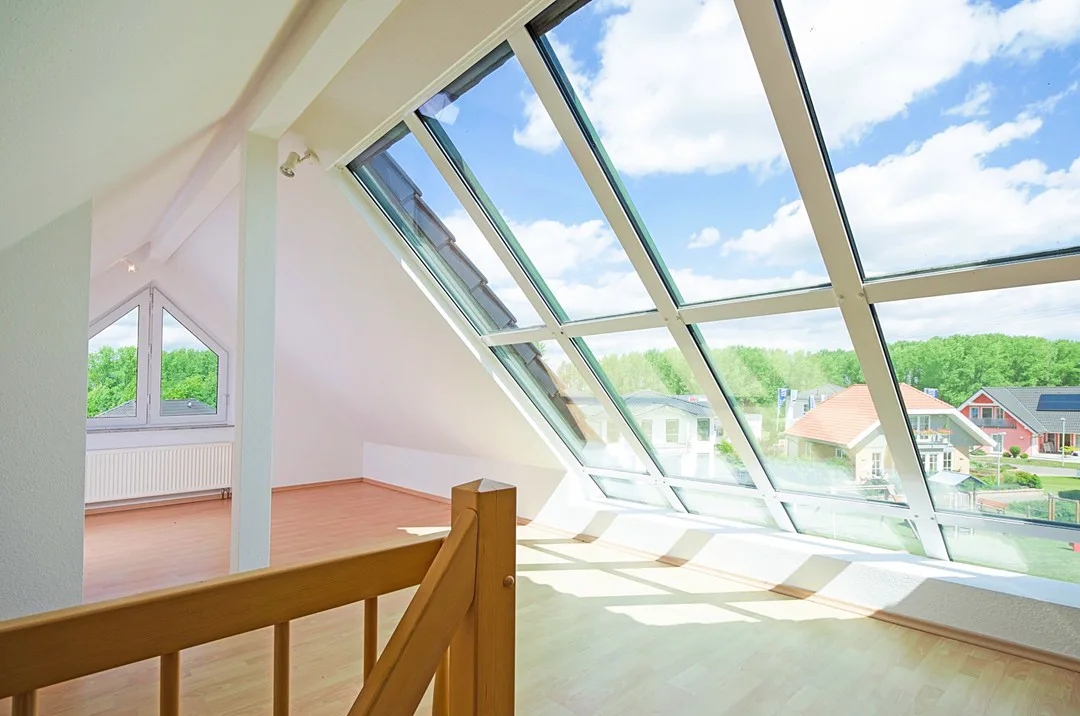 Dachgeschoss mit großer Dachverglasung und Blick ins Grüne