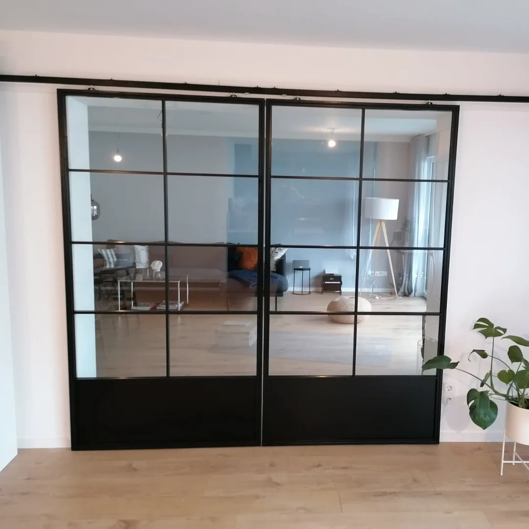 Schiebetür aus Stahl und Glas zwischen Wohnbereich und Flur